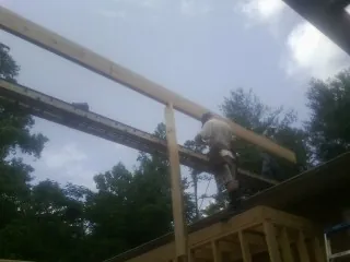 Carpenter setting a ridge beam over a new addition frame — Ice Dam Removal by Roofing Brothers in Wheeling